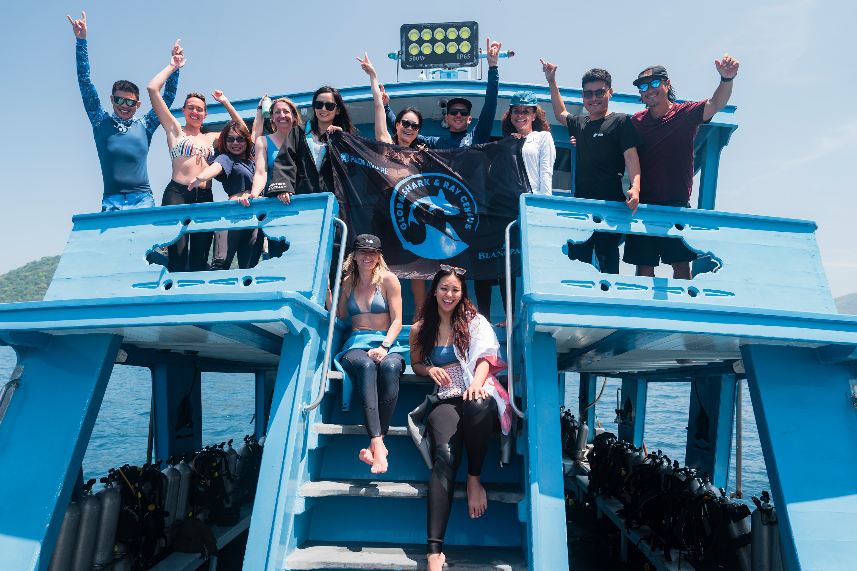 Team of divers posing on a dive boat