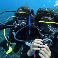 Close up of two young divers underwater, Junior AmbassaDivers Julia and Alexa Wong