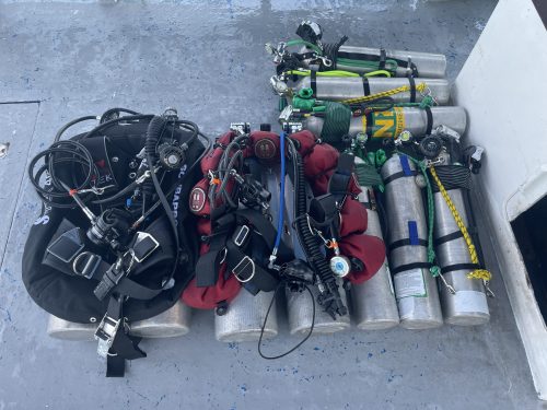 Tec diving gear layed out on the ground for two divers