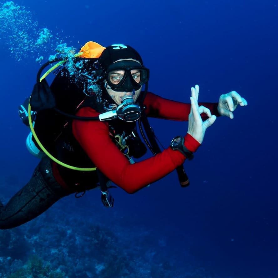 Ocean Torchbearer Award Winner Amanda Van Jaarsveld diving underwater and giving an ok sign